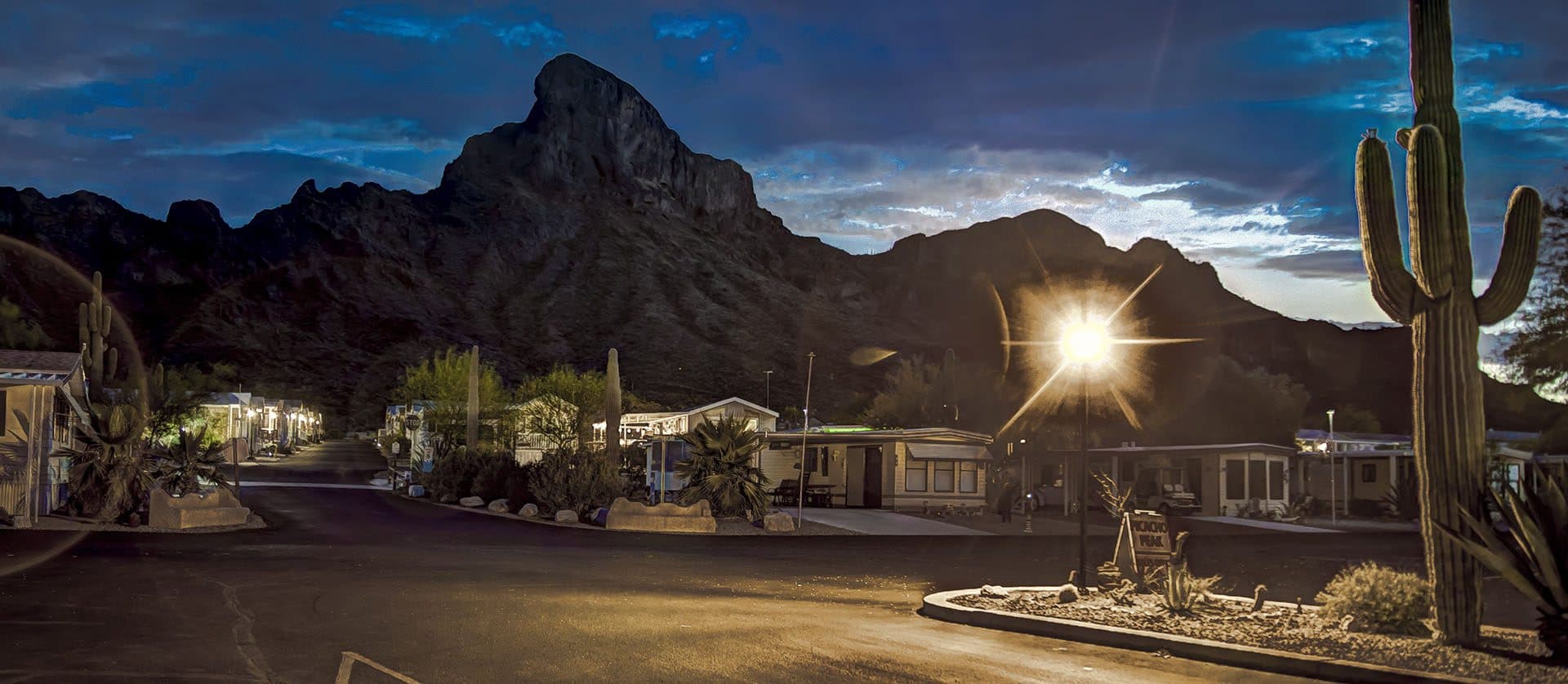 Picacho Peak silhouetted at dusk above the resort as the streetlights glow.