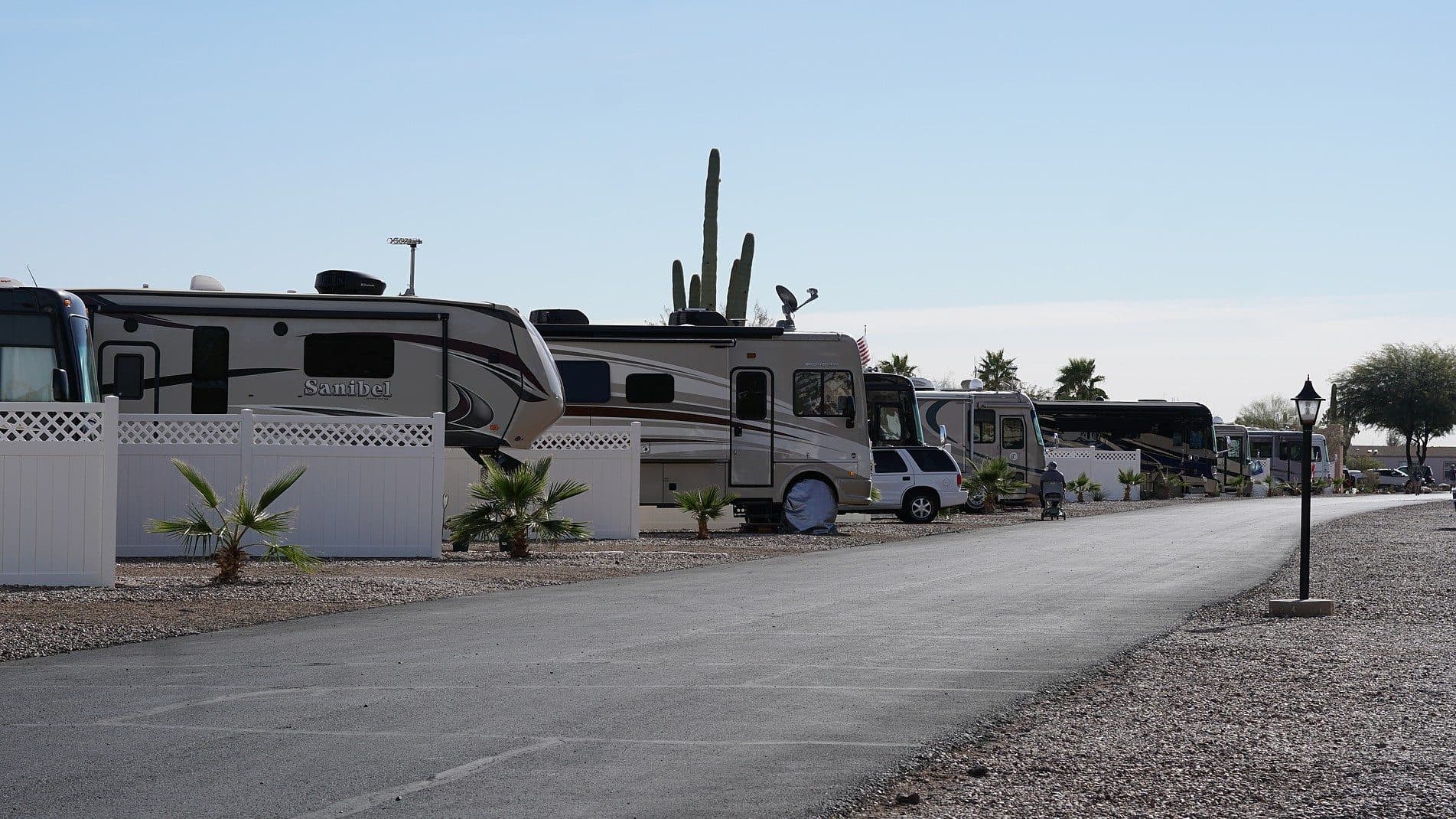 RVs parked at their sites along a paved road at Picacho Peak RV Resort.